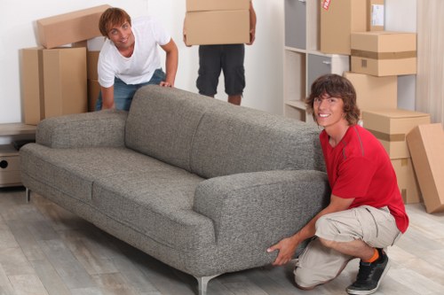 Movers carrying furniture during a home relocation in Honor Oak